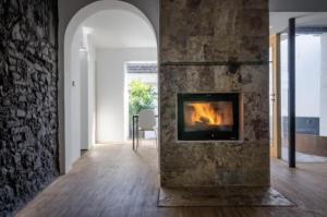 a fireplace in a living room with a stone wall at Fuentes de León in Fuentes de León