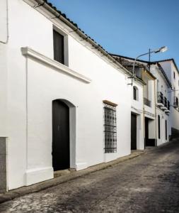 a white building with a black door on a street at Fuentes de León in Fuentes de León