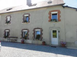 a white house with potted plants on the windows at Gîte G337 in Quibou