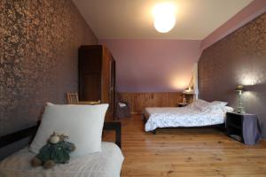 a bedroom with two beds and a couch and a tv at Gîte G40 in Marchésieux