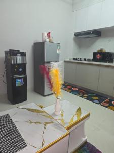 a kitchen with a vase with feathers on a table at Maggy Homes in Marimbeti