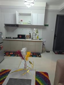 a kitchen with a sink and a table in a room at Maggy Homes in Marimbeti
