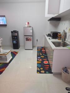 a kitchen with a sink and a refrigerator and a rug at Maggy Homes in Marimbeti