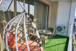 a hammock in a balcony with a table and chairs at Jimi Comfort Stay in Bamgbose