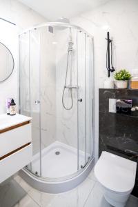 a white bathroom with a shower and a toilet at Super Central Modern Flat with Balcony & View! #55''Smart TV #Fast Wi-Fi #Metro in Warsaw +32 photos