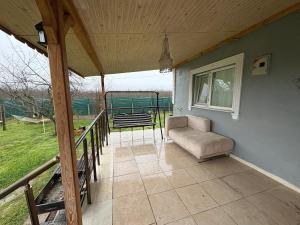 a covered porch with a chair and a window at Liva Kartal in Karasu