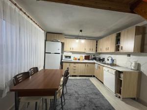 a kitchen with a wooden table and a kitchen with white appliances at Liva Kartal in Karasu +12 photos