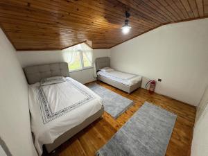 a bedroom with two beds and a window and wooden ceilings at Liva Kartal in Karasu