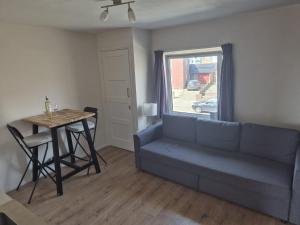 a living room with a blue couch and a table at Studio At C in Zandvoort +4 photos