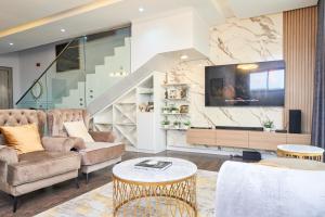 a living room with two couches and a tv at Jimi Comfort Stay in Bamgbose