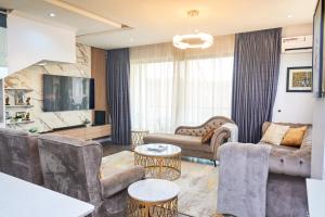 a living room with couches and tables at Jimi Comfort Stay in Bamgbose +9 photos