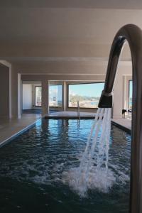 a pool with a water fountain in a house at Hotel Club S'Illot in S'Illot