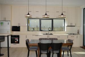 a kitchen with a table and chairs and a window at Villa White Dolphin Kaprovani in Ureki