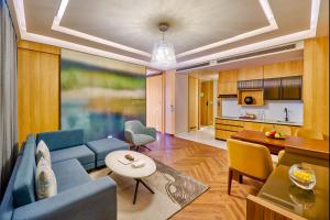 a living room with a blue couch and a kitchen at WelcomHotel by ITC Hotel Mohali, Chandigarh in Chandīgarh