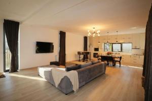 a living room with a couch and a dining room at Villa White Dolphin Kaprovani in Ureki