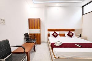 a hotel room with a bed and a chair at Premium-Ram-Krishna-Palace in Ayodhya +9 photos