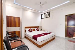 a bedroom with a bed and a chair in it at Premium-Ram-Krishna-Palace in Ayodhya