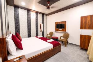a hotel room with a bed and a tv at Premium-Ram-Krishna-Palace in Ayodhya