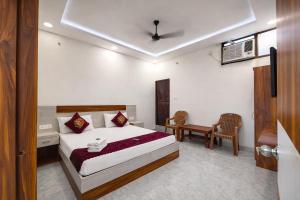 a bedroom with a bed and a desk and a table at Premium-Ram-Krishna-Palace in Ayodhya