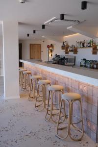 a row of stools at a bar in a restaurant at Hotel Club S'Illot in S'Illot