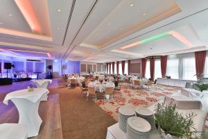 um salão de banquetes com mesas brancas e cadeiras brancas em See und Sporthotel Ankum Lakeside Apartments em Ankum