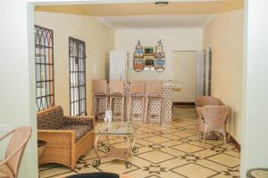 a living room with a glass table and chairs at Newfavourlodge in Nkoanrua