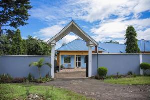 a house with a white wall and a gate at Newfavourlodge in Nkoanrua +18 photos