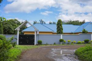 a house with a blue roof and a driveway at Newfavourlodge in Nkoanrua