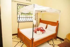 a bedroom with a bed with a canopy at Newfavourlodge in Nkoanrua