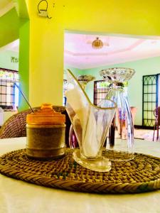 a table with a plate with a cake and a glass pitcher at Newfavourlodge in Nkoanrua