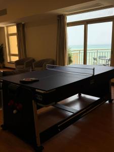 a ping pong table in a living room with a view at Beach view in King Abdullah Economic City