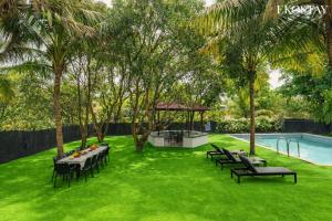 a garden with a table and chairs and a pool at EKOSTAY Gold - Amara Villa in Alibaug