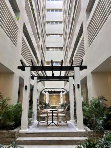 a patio with a table and chairs in a building at Saint Honore - La Casa De Khea in Sampong