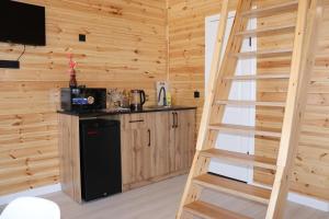 a kitchen with a staircase in a log cabin at Barn Peaks Karakol in Karakol