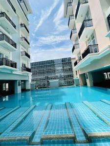 a swimming pool in the middle of two buildings at Saint Honore - La Casa De Khea in Sampong