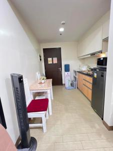 a small kitchen with a table and a red chair at Saint Honore - La Casa De Khea in Sampong