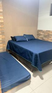 two beds in a room with blue sheets and pillows at Espaço Beatriz in Aparecida +26 photos