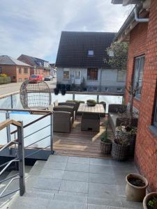 a deck with couches and tables on a house at Skøn lejlighed i centrum in Herning