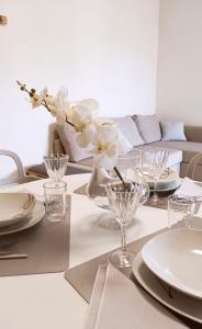 a dining room table with white plates and flowers in a vase at Spacious, renovated apartment in the centre in Montecatini Terme