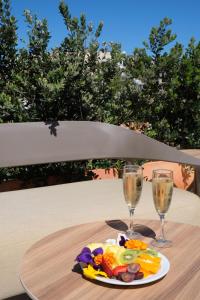 a plate of food and two wine glasses on a table at Hotel Club S'Illot in S'Illot +54 photos
