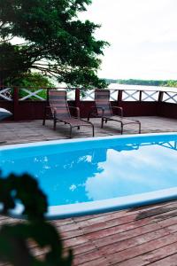 two chairs and a swimming pool on a deck at Vista do Lago Jungle Lodge in Cajual