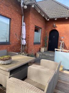 a patio with a table and chairs and a brick building at Skøn lejlighed i centrum in Herning
