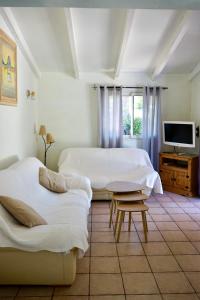 a bedroom with two beds and a table and a tv at Résidence Itylon in Cargèse