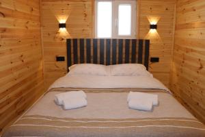 a bedroom with a bed with two towels on it at Barn Peaks Karakol in Karakol +13 photos