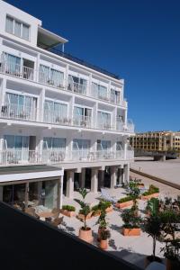 a large white building with trees in front of it at Hotel Club S'Illot in S'Illot