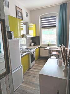 a kitchen with yellow and white appliances and a table at Centrum 2pokoje 4łożka przy MACDonald ulica Witosa 1 in Piła