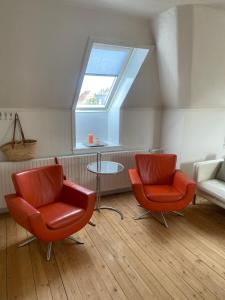 a living room with two chairs and a table at Skøn lejlighed i centrum in Herning