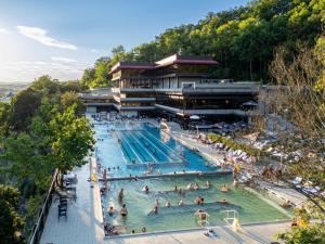 a large swimming pool with people in the water at Hotel Thermal in Karlovy Vary