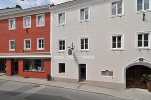 een wit gebouw in een stadsstraat met gebouwen bij Pension Sendlhofer in Radstadt