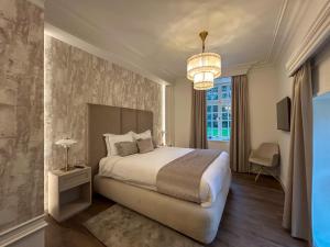 a bedroom with a large bed and a chandelier at Hotel Kasteel Oost in Valkenburg +85 photos